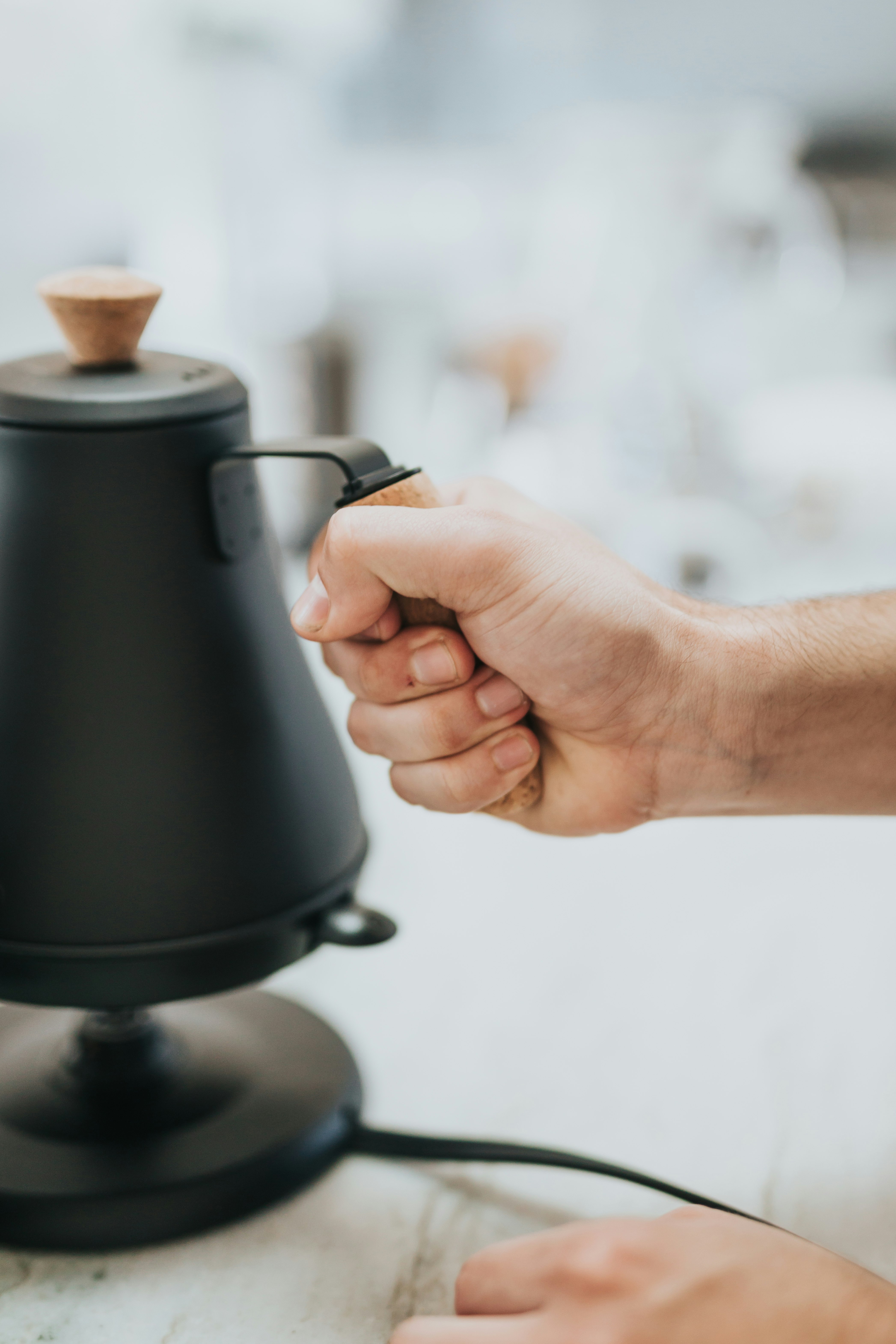 person holding black and silver thermal carafe